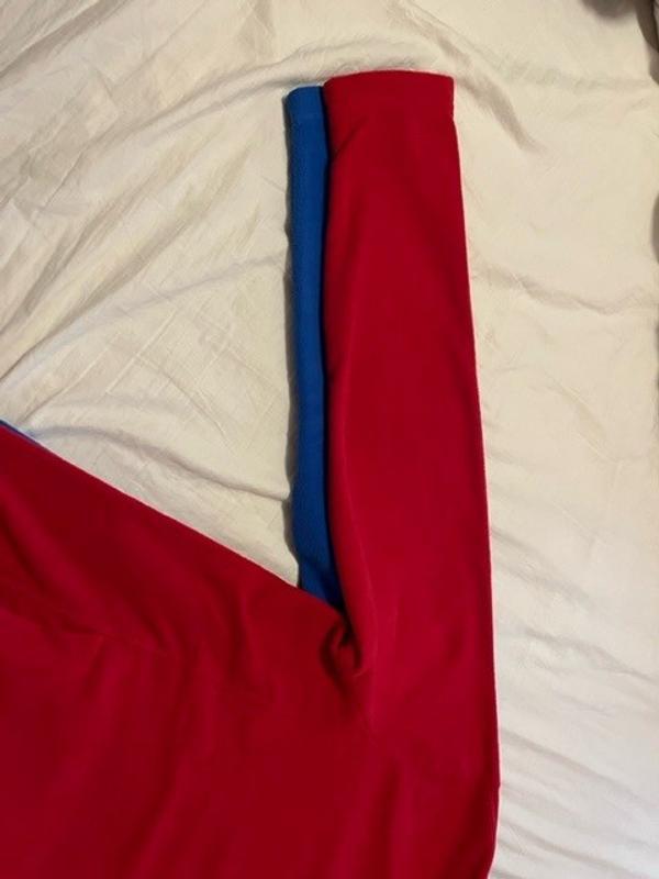 sleeves on the new red fleece are 1" narrower than last year's blue fleece.