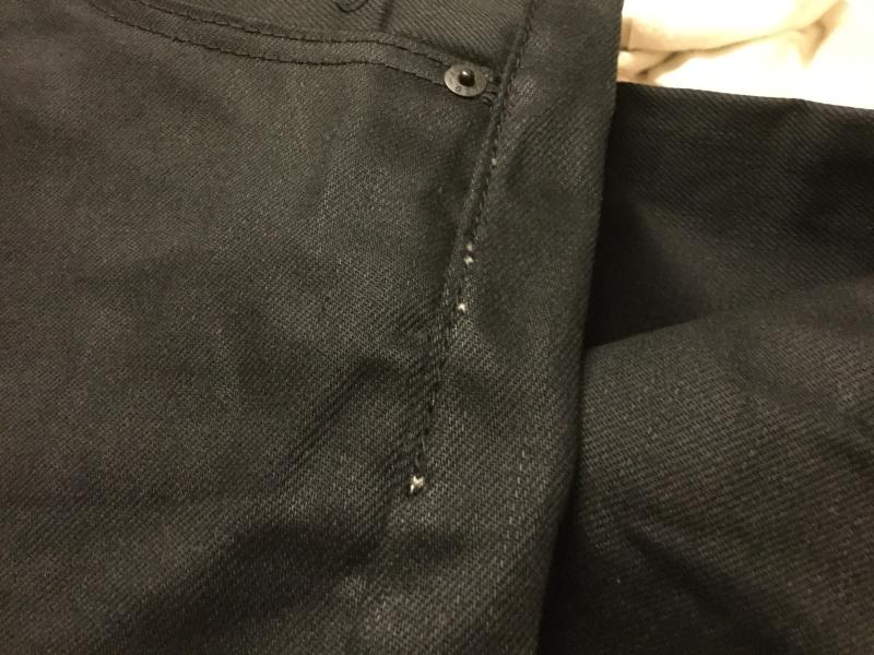 White pocket material torn and ripped sticking out of side seam.  Maybe a snag during stitching?
