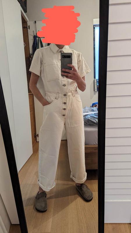 white sleeveless jumpsuit with a white tshirt underneath