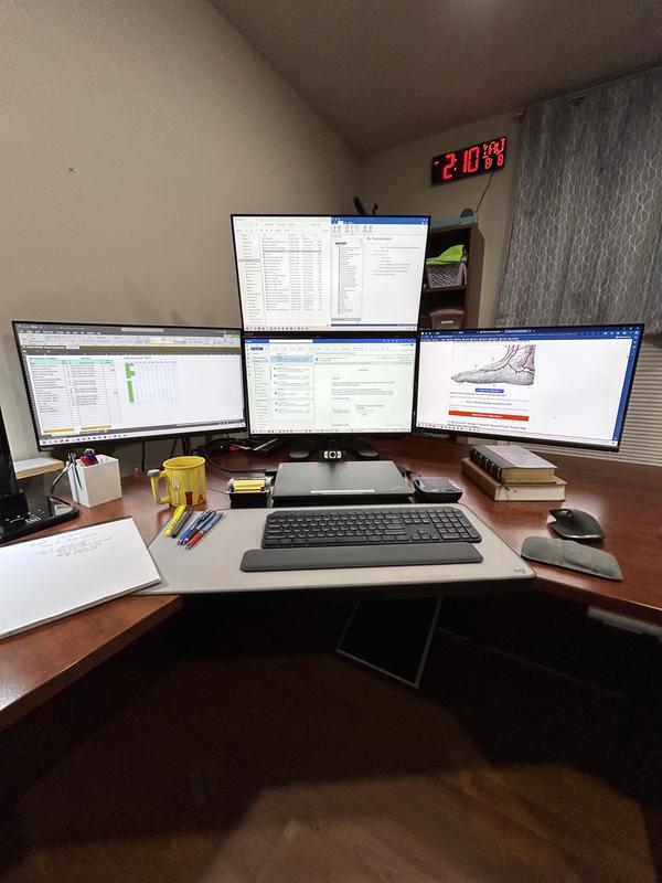 It is difficult to see the ThinkPad Thunderbolt 4 Workstation Dock in this photo because it is tucked under the lower left corner of the center monitor. One end of the dock is exposed for me to press the on button to begin my work day. It is versatile.