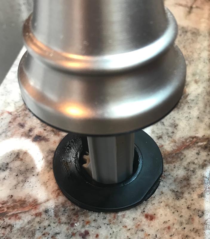 Black plastic ring mounted to countertop has a flaw.