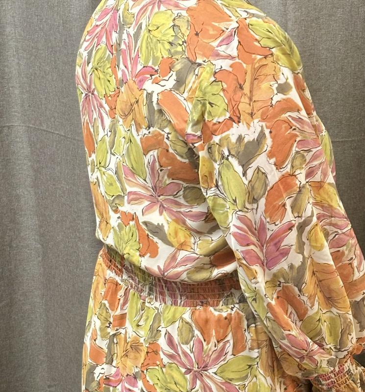 Gathered waist and sleeves with strings to tie at neckline.