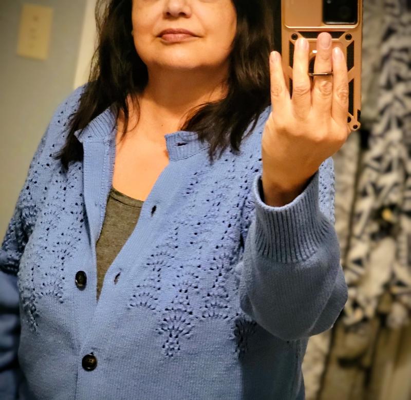 The sweater is a lovely shade of blue and has nice crochet detail.