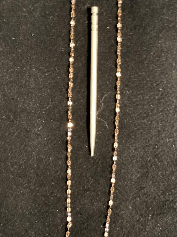 Necklace next to regular toothpick