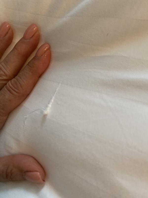 It looks like the Fabric must have had a tear, and it was over stitched to fix it. I would deemed these at seconds.