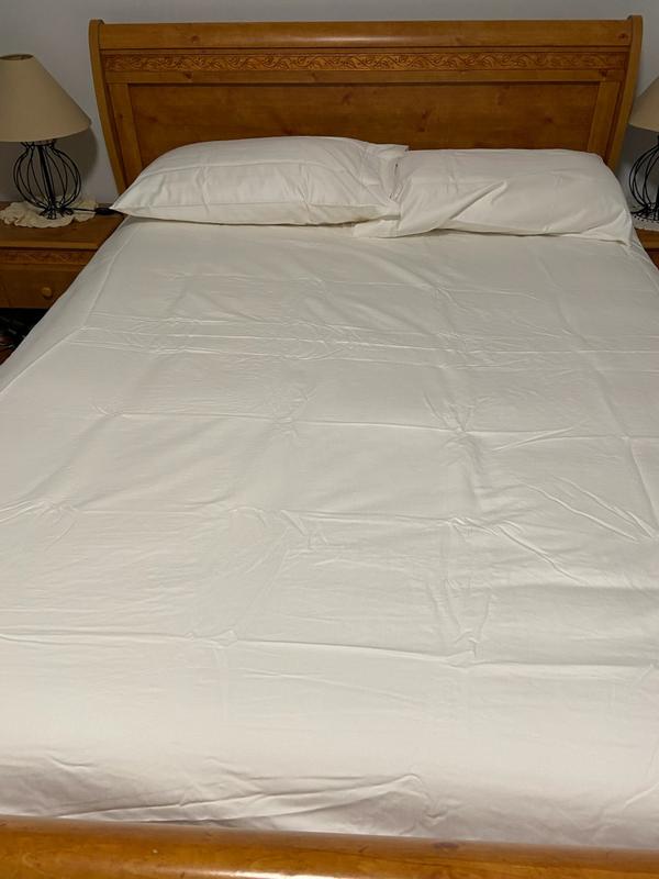 A deep, plush queen sized bed with standard pillows