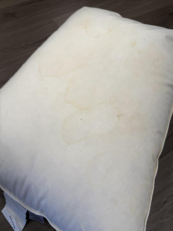 Both sides of the pillow covered in sweat stains and other stains.