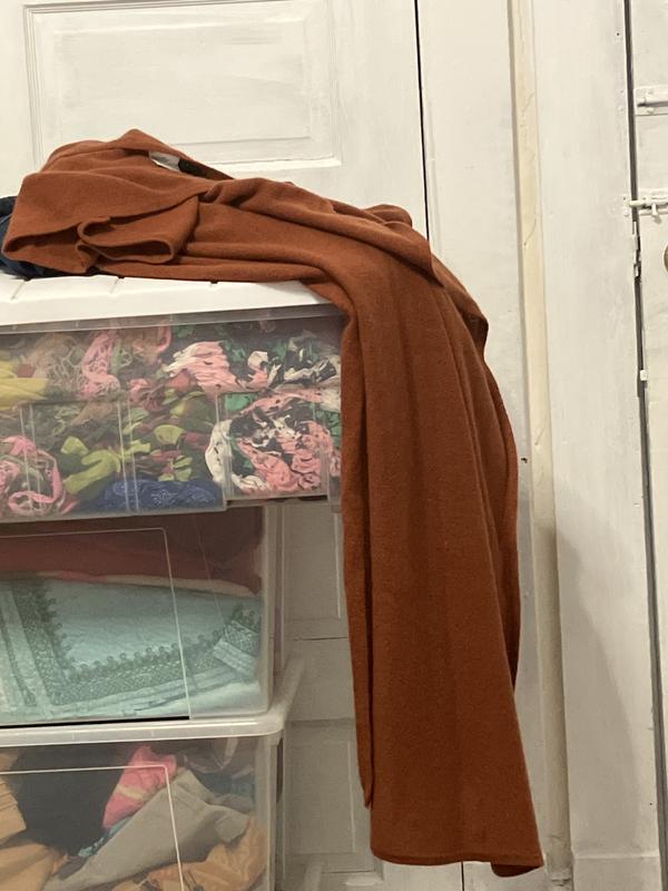 Laying across my other scarves as it is frequently worn.