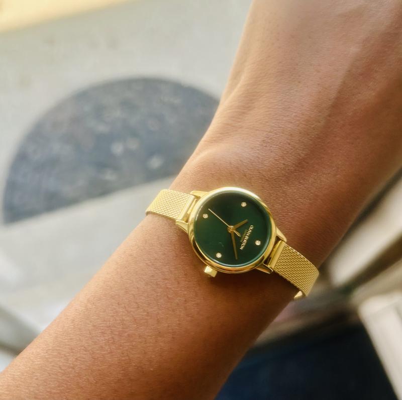 The watch has a beautiful, deep green face with a gold dial and four crystals to mark every quarter hour.
