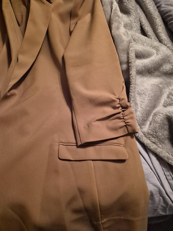 The rouched sleeve gives an added looked of rolled up sleeves