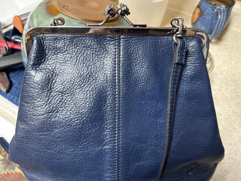 Not terribly user friendly..the loops fall down into the bag, the strap follows, the bag won’t close and you have to fuss with it. Beautiful bag though!!