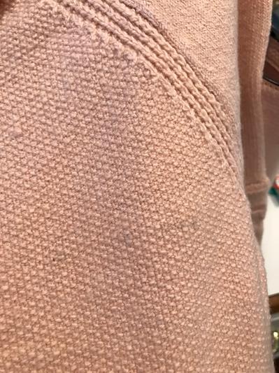 Line of dark threads across sweater front