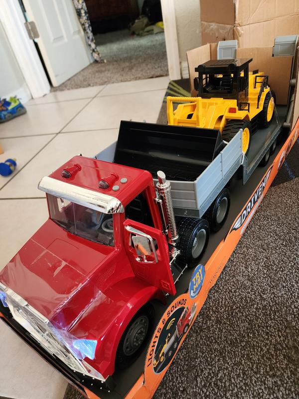 Small Toy Truck Carries A Large Black Subwoofer Or Audio Speaker