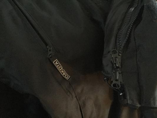 Cloth tab attached to one zipper but broken off the other