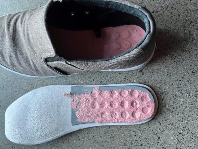 Under side of foot bed showing paperboard flaking off