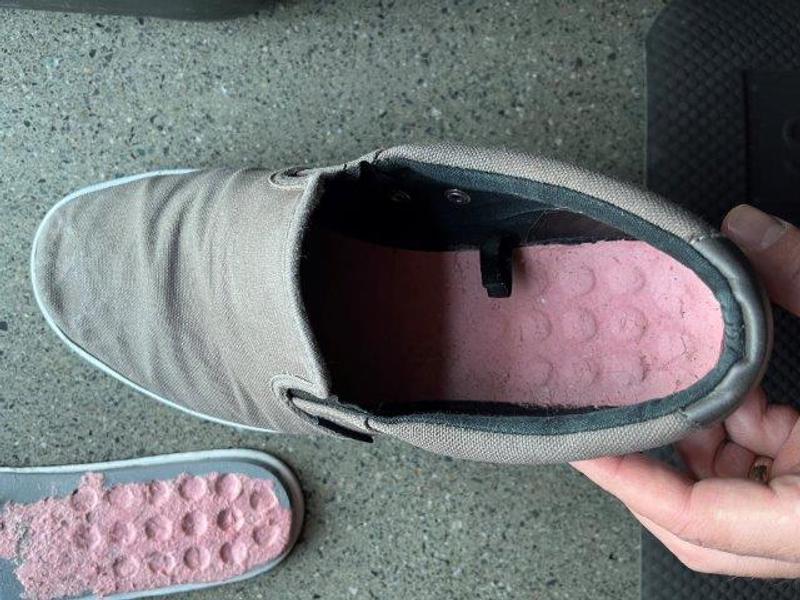 Inside shoe showing remnants of pink paperboard layer