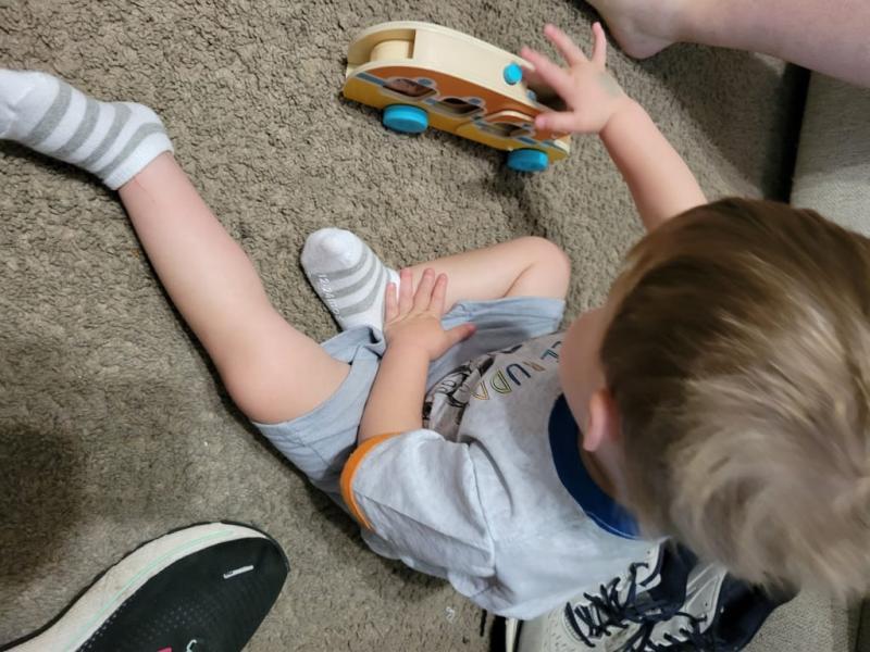 Figuring out what the button on the top did took him a minute but he loves that the little people roll out