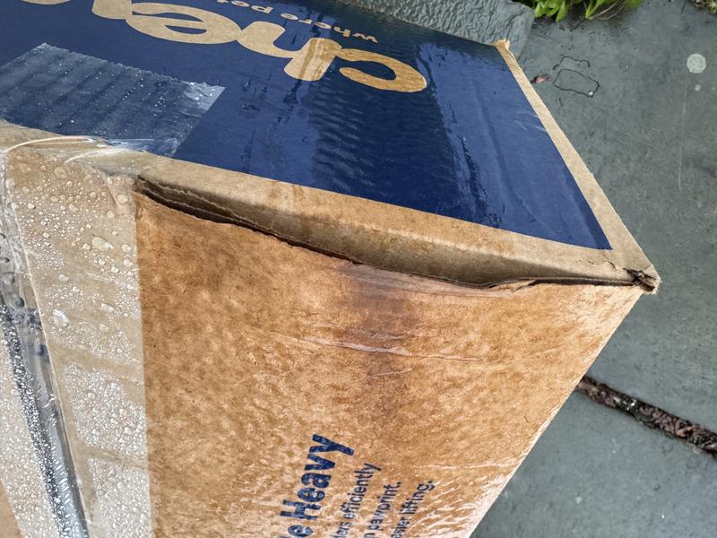 Soaked package where you can see rain water going inside the package .