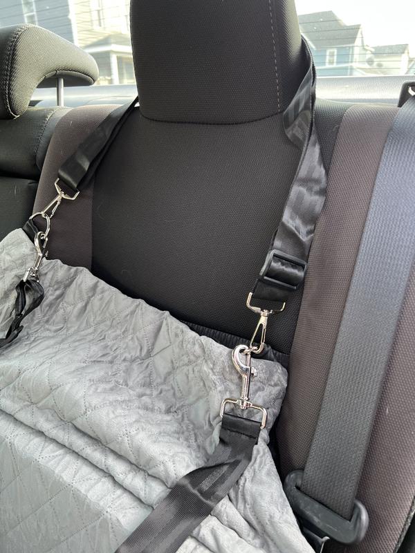Photo showing how the strap to secure to the car headrest is tightened all the way but still a little loose.