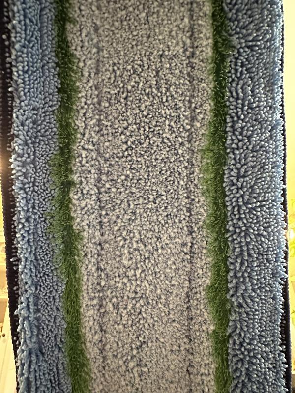 Close up of the blue deep-cleaning pad. The green stripe is a scrubber-type material that does not scratch.
