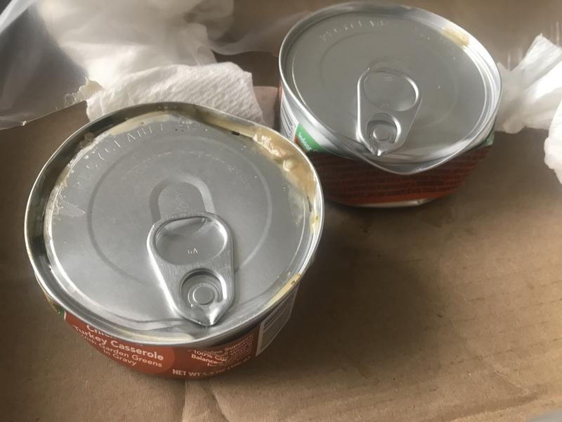 Both cans popped and drained some contents all over other cans in pack