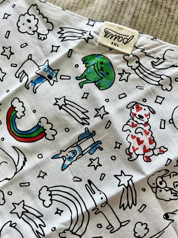 Bandana.  The outside features a print of dogs, rainbows, shooting stars, and confetti.  It is in the process of being coloured in.