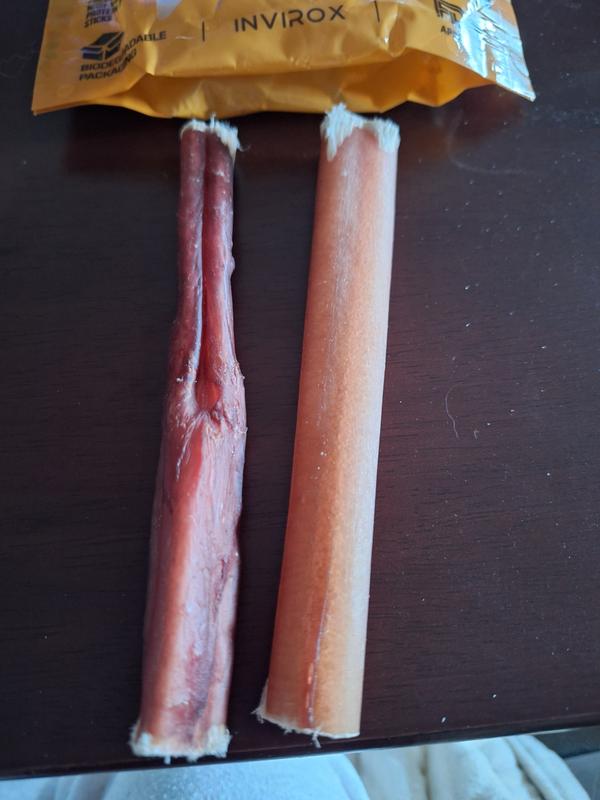 Customer photo from a Chewy review: two INVIROX grass-fed beef bully sticks on a table