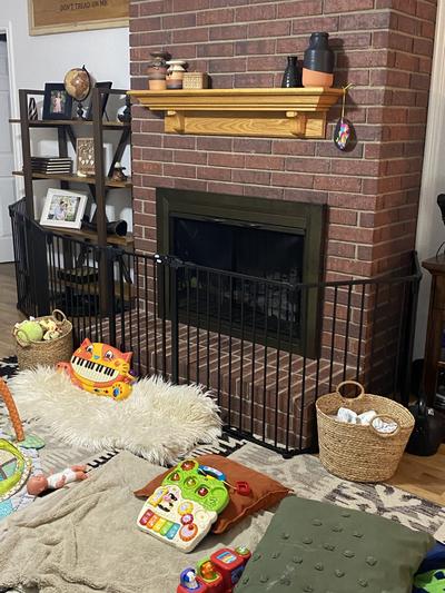 Playpen fully extended around fireplace and shelf