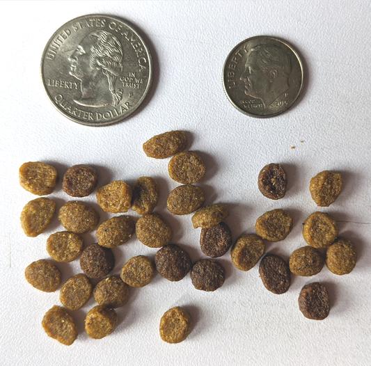 Cat food pellets with coins for scale.