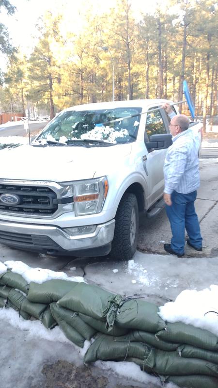 Scraping snow off truck.