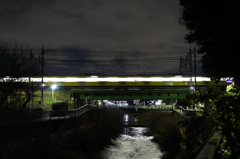 Lowlight Slow shutter of a train crossing a bridge in Tokyo