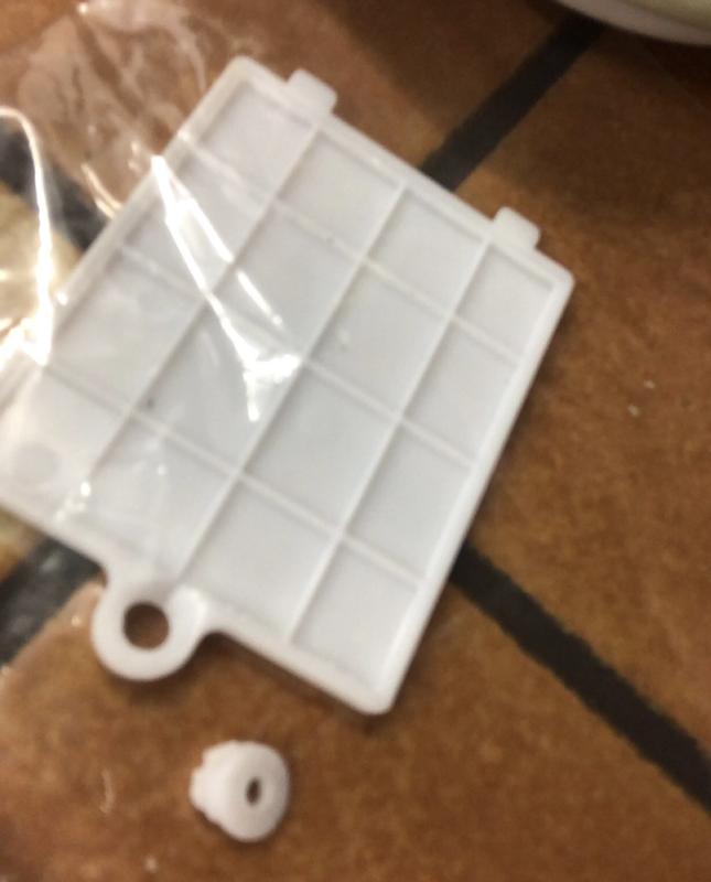 The broken cover plate.  That little plastic piece is supposed to be a part of the screw hole.