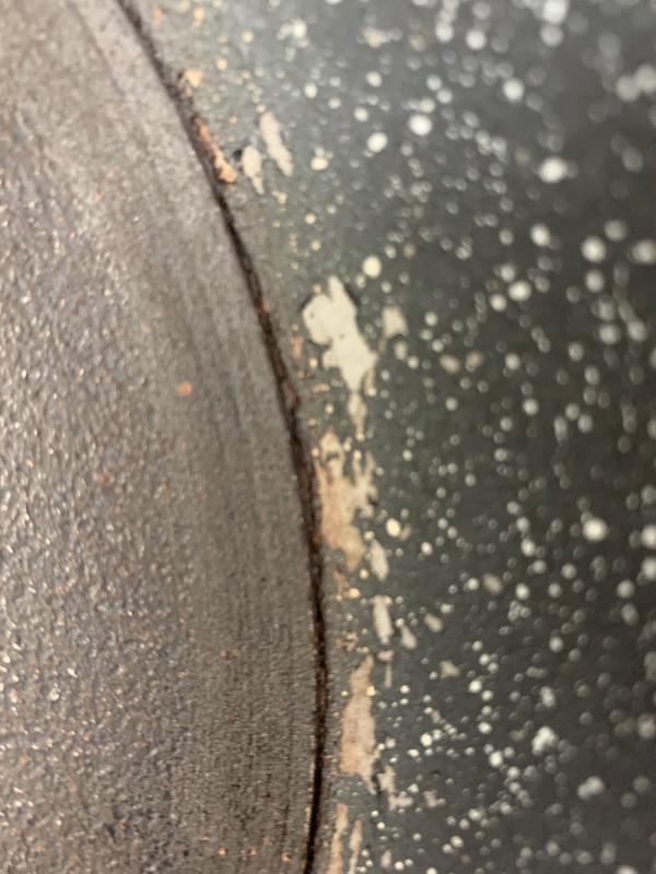 Replacement fry pan split, but not through. Flaking happened post split.