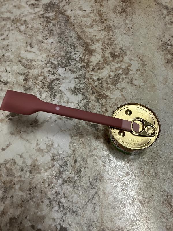 Using the end of the spatula to open the pull tab on a cat food can