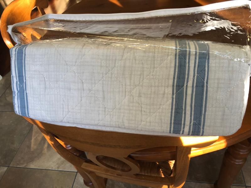 The quilt is a white/grey blended plaid with a blue stripe.