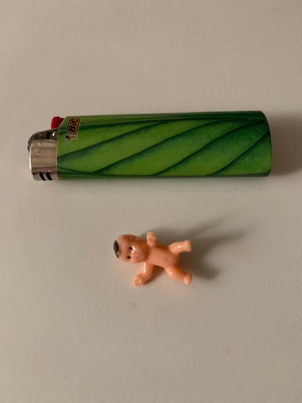 Plastic baby found in my Purex baby laundry detergent. Used lighter to show actual size.