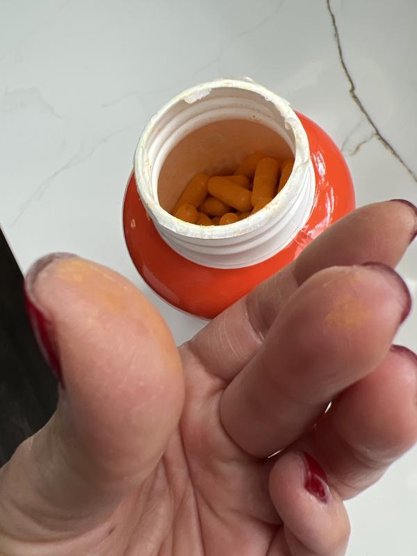 Barely touched one capsule and fingers have golden film on them.  Capsules are covered with powder.