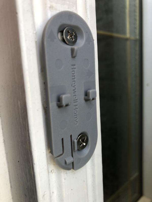 Locking tab at bottom left of mounting bracket needs to be pushed with a small screwdriver towards the door frame to release the assembly upwards