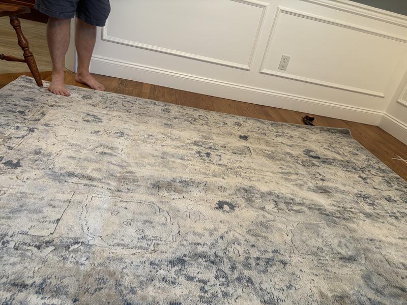 You can see what looks like a bubble under the rug. It’s a stretched area that want lay flat. It’s not in a fold.