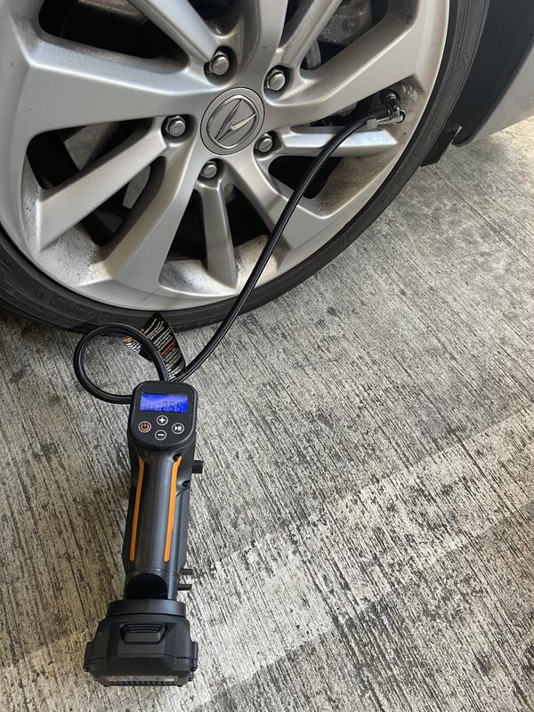 Portable inflator attached to car tire