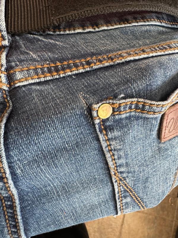 Tearing at the right rear pocket rivet