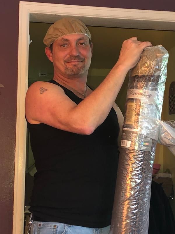 Hubby unrolling the new rug! The ends come with the thing on his head to protect the ends!