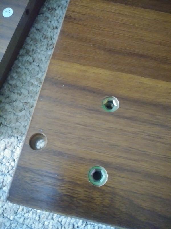 The hole on the far left is the one the screws are supposed to go to attach the side board for the drawer to the bottom board