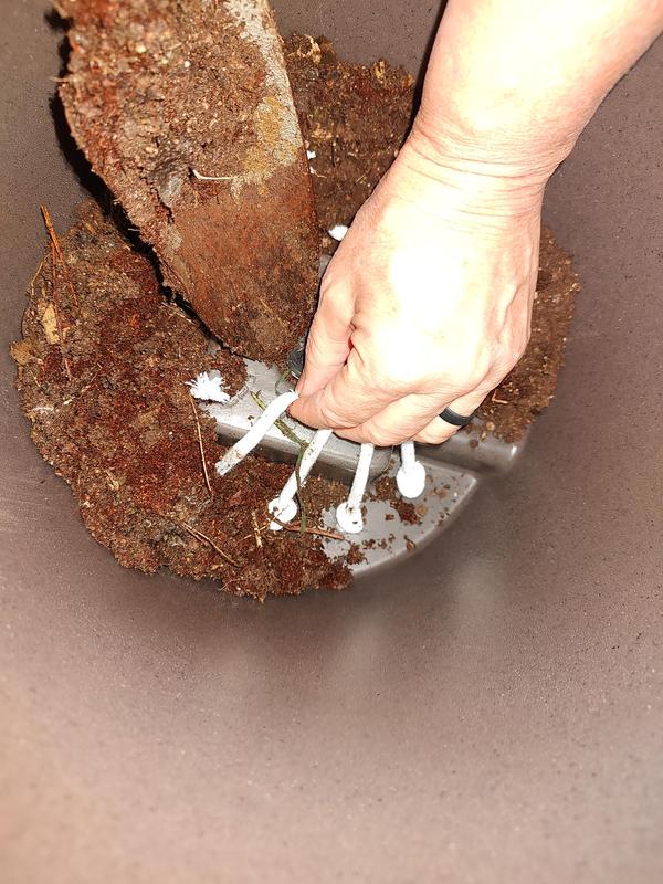 Hold the wicking chords up when first filling the planter base with soil.