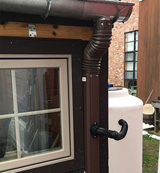 Rain barrel hooked up to gutter downspout. Pure rain water for the garden!