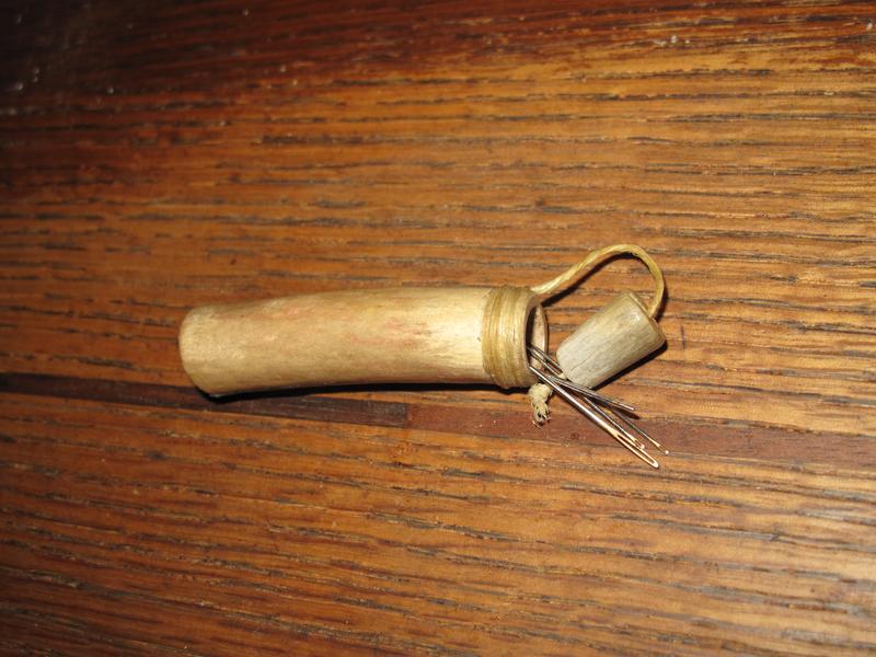 Antler needle case with sinew wrap, sealed with pine tar.