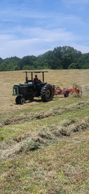 my 11 year old son raking hay on the old deere