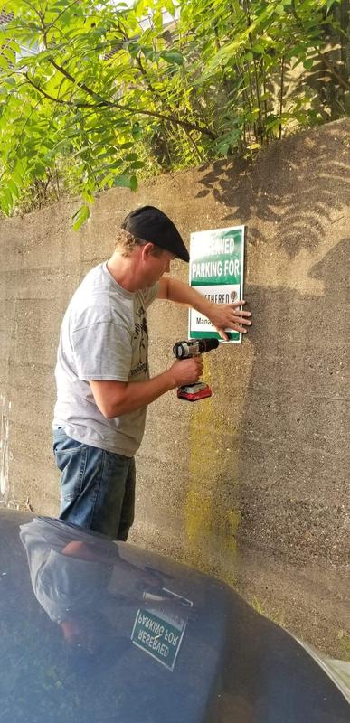 Hammer drilling this sign on concrete wall. I couldn't use my corded hammer drill out in the parking lot.