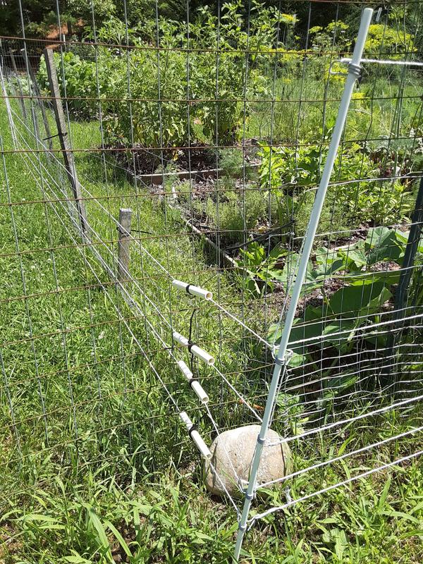 Homemade insulators at existing metal fence
