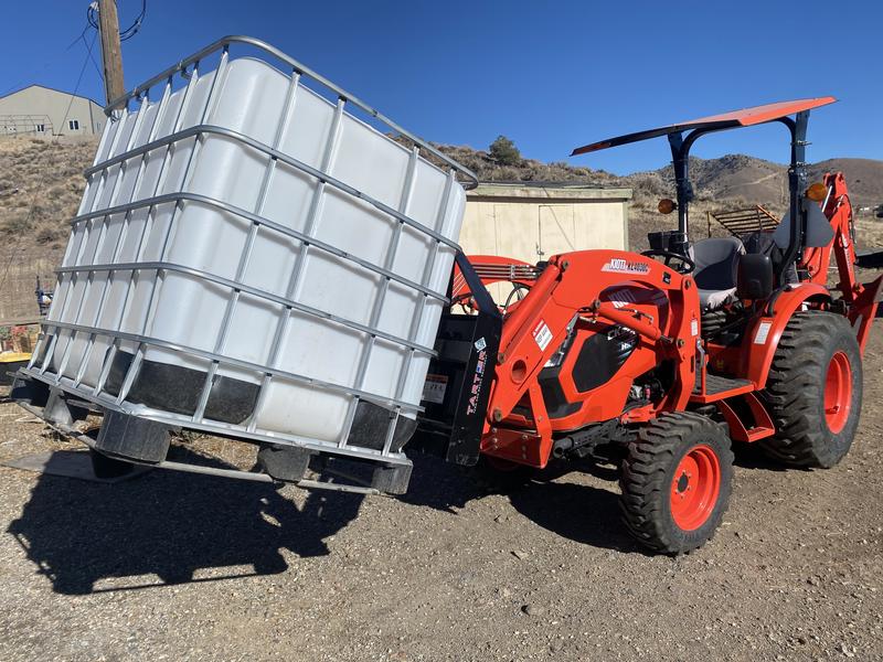 This is a 275 gallon IBC tote. The forks are long enough to fit completely through.